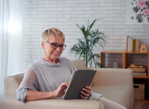 femme souriante devant son Ipad Europ Assistance