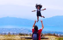 Papa faisant sauter sa fille en l'air dans le ciel